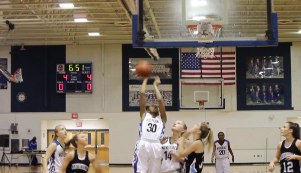 Varsity basketball player RaSheika Gregory (center) scores at a home game against Centreville. 