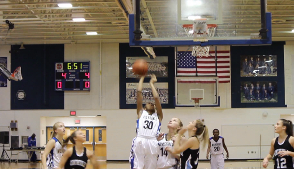 Varsity basketball player Ra'Sheika Gregory (center) scores at a home game against Centreville. 