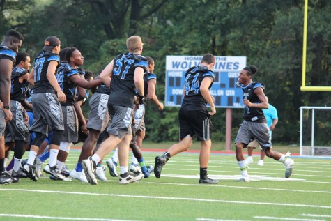 Football team members participate in a pep rally activity.