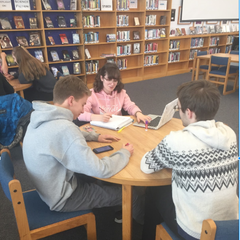 Three seniors work on an assignment.