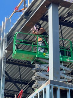 A county construction worker completing the building envelope. Once the outside is complete, the focus shifts indoors.