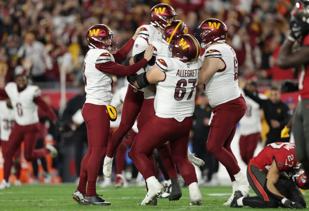 The Commanders celebrated with kicker Zane Gonzalez after he doinked the football off the upright and into the goal for the Commanders first playoff win in two decades.