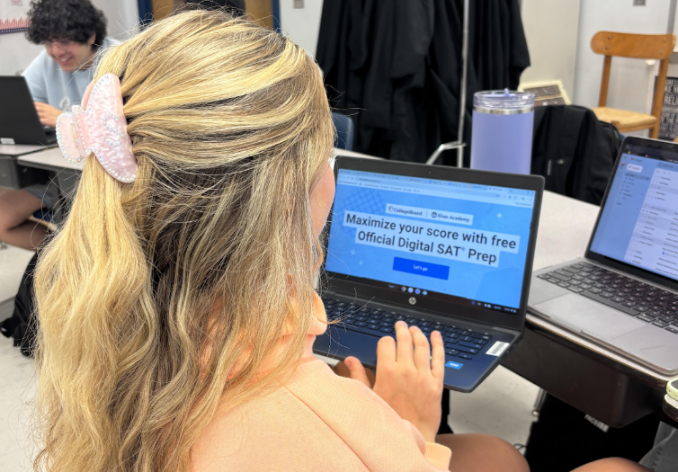A student in class using free prep resources to study for their upcoming SAT.
